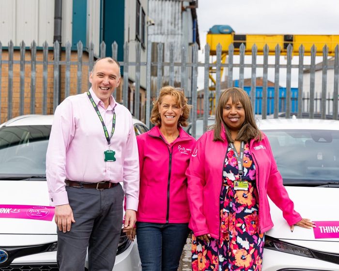 DG Cars staff beside Think Pink liveried vehicles